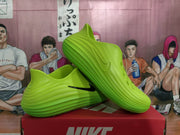 Angled side view of the green sneakers displaying the perforated upper, sculpted sole, and black side logo.