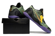 Black, green, and purple shoes displayed on a black shoebox.