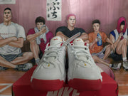 Front view of white Nike sneakers with red toe and outsole accents.
