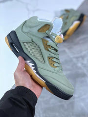 Front three-quarter view showing green laces, padded tongue, mesh side panel, and speckled white midsole detail.