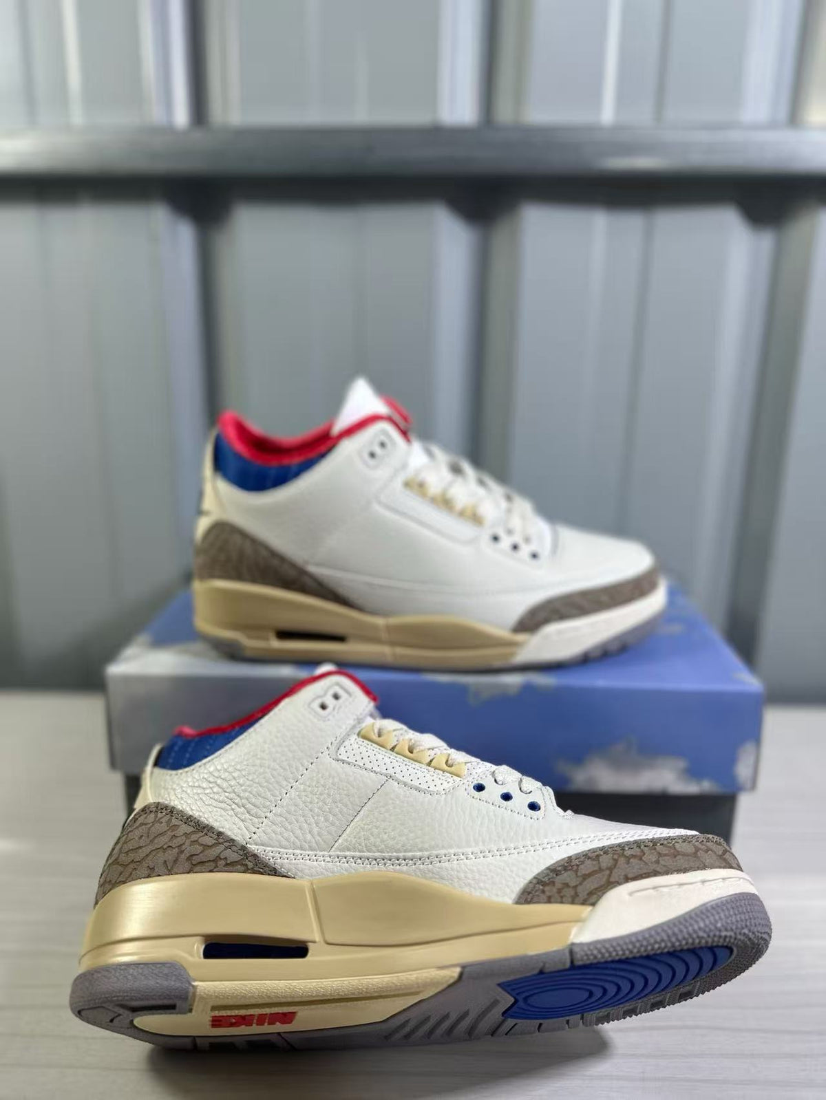Pair of white Air Jordan 3 sneakers with brown elephant-print overlays, cream midsoles, and blue outsole accents.