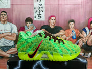 Side view of green Nike basketball sneakers with black laces, red-and-black side branding, and a neon outsole on a black shoebox.
