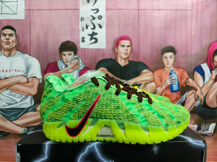 Side view of green Nike basketball sneakers with black laces, red-and-black side branding, and a neon outsole on a black shoebox.