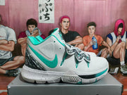 Side view of white Nike Kyrie basketball shoes with mint-green accents, patterned heel and speckled midsole.