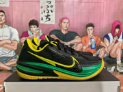 Side view highlighting the contrasting Nike-style side mark, green midsole detail, and yellow patterned outsole.