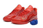 Pair of red Nike LeBron 23 basketball shoes shown from a front three-quarter angle with blue laces.