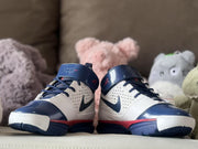 Front view of the pair displaying the navy toe areas, white panels, and red midsole accents.