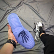 Bottom view showing the translucent blue outsole of the white and silver high-top sneaker.