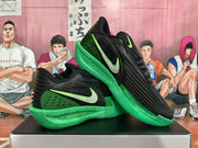 Angled view of the pair highlighting the black-and-green color scheme and textured outsole.