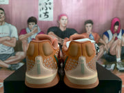 Rear view showing the padded heels, contrasting heel panels, patterned side details, and cream-colored midsoles.