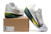 Off-white Nike Zoom Fly 6 shoes with dark green and yellow accents beside a box showing a sample size label