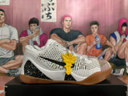 Side view of a white basketball shoe with black logo, speckled heel detail and gum outsole