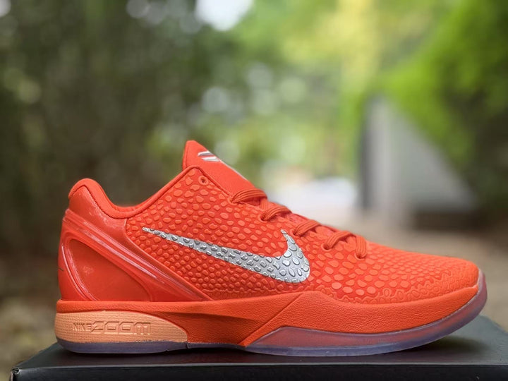 Side profile of an orange Nike Kobe 6 sneaker with a silver Swoosh and textured upper.