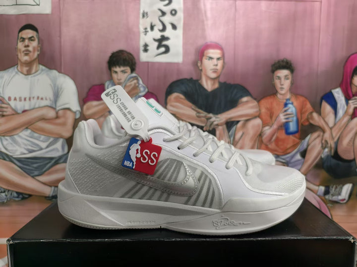 Pair of white Nike basketball sneakers shown in side view with gray Swoosh detailing and basketball-themed hangtags.