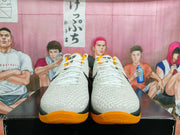 Front view showing the textured white toe boxes, white laces, black trim, and gold outsoles.