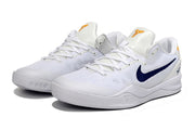 Pair of white Kobe 8 sneakers with a dark navy swoosh and gold tongue branding.