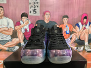 Front view of black-laced sneakers showing the purple-blue galaxy-patterned toes, tongue branding, and translucent outsoles.