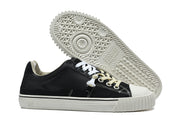 Black sneaker beside a view of its patterned white outsole.