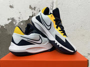 Pair of white, navy and yellow Nike basketball shoes shown from the side