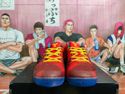 Front view of red Nike basketball sneakers with yellow patterned laces, yellow tongue branding, and blue outsoles.