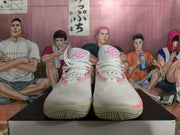 Front view of white basketball shoes with pink details and white laces