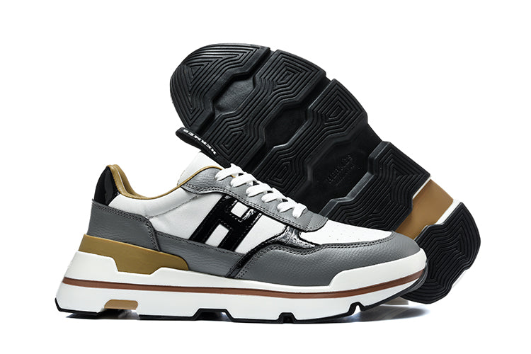 Side view of gray, white, black, and tan low-top sneakers with a chunky sole; one shoe is shown outsole-up.