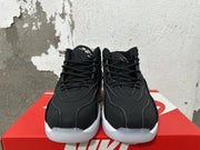 Front view of black lace-up Nike sneakers with grey and white sole details.