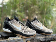 Three-quarter view of the Nike Kobe 6 sneakers with beige, black, and light-colored details.