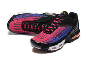 Top view of black sneakers with bright pink and purple gradient uppers and black laces.