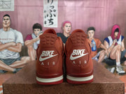 Rear view of red low-top sneakers showing heel branding, tonal panels, and a light-colored midsole accent.