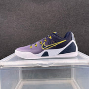 Side view of a Nike sneaker in dark navy, purple and white with yellow Swoosh detailing, displayed on a clear case.