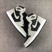 Pair of black and grey sneakers arranged diagonally on a textured surface.