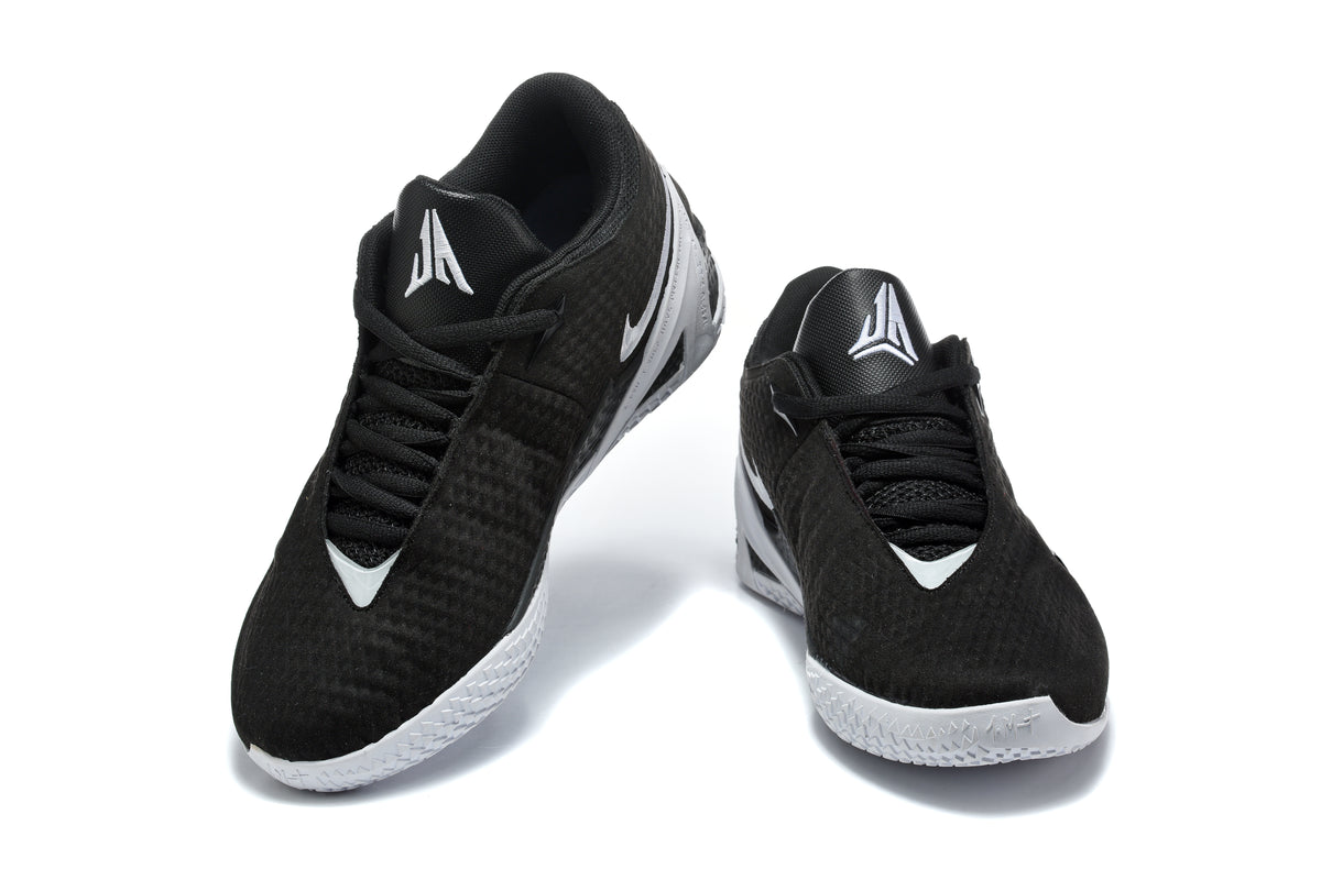 Pair of black low-top basketball shoes with white and silver accents shown from a front three-quarter angle.