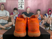 Rear view of the orange Nike Zoom sneakers showing padded collars, sculpted heel sections, and signature-style heel markings.