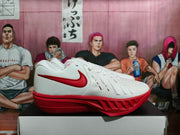 Side profile of a white low-top basketball shoe with red Swoosh detailing and a red sole.