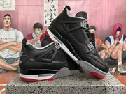 Angled view of paired black and red high-top sneakers highlighting the side panels, grey midsole details, and red outsole.