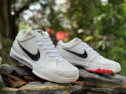 Angled view of the white Kobe 4 shoes with perforated toe areas