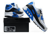 Nike Air Max 90 sneakers in white, grey, blue, and black shown with a shoe box; the box label shows a sample size.