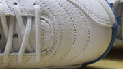 Close-up of the white textured upper, stitching, and white laces.