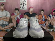 Front view of white Nike sneakers with laces, layered toe panels, tongue branding, and sculpted soles.