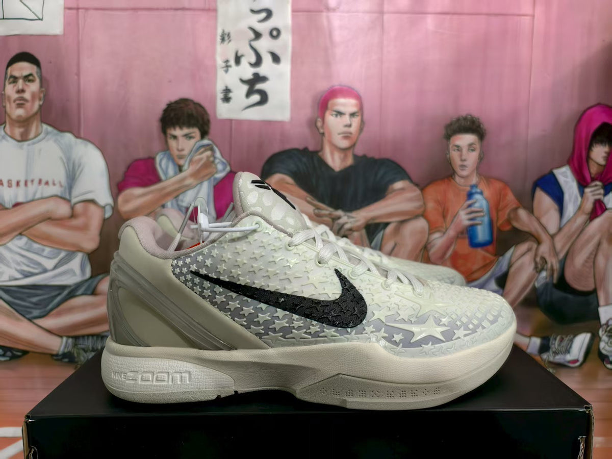 Side view of light white Nike basketball sneakers with raised textured detailing, black side swoosh, white laces, and sculpted midsole.