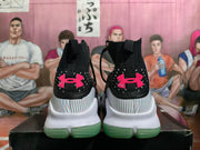 Rear view showing pink Under Armour heel logos and translucent green outsole sections.