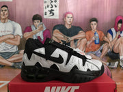 Side profile of a black and white Nike sneaker showing the layered upper, swoosh logo, and molded black outsole.