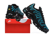 Black and blue Nike Air Max Plus sneakers beside a red Nike shoe box.