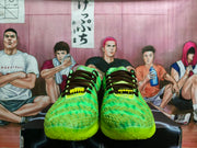 Front view showing the green textured toe boxes, black laces, yellow lace details, and neon outsole.