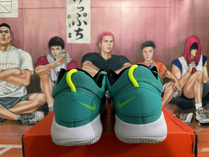 Rear view of black and teal Nike basketball shoes with volt heel accents