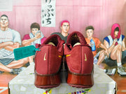 Rear view of burgundy Nike shoes with small gold Swoosh accents and translucent heel sections