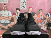 Front view of black high-top basketball shoes with lace-up fronts and white outsoles.