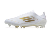 Side view of a white adidas F50 laceless soccer cleat with gold-colored detailing and a studded outsole.
