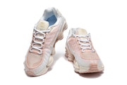 Front and top views of white and pale pink Nike Shox TL sneakers.